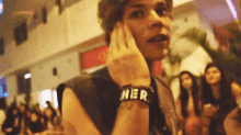 a man is wearing a wristband that says her on it