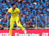 a man wearing a yellow shirt with the word emirates on it