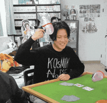 a man wearing a black sweater that says kosmix noise