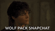a young man with curly hair is looking away from the camera and says `` wolf pack snapchat '' .