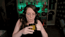 a woman wearing headphones and glasses is holding a mug with the word pubg on it