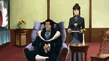 a man sits in a chair while a woman holds a plate of food