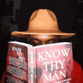 a man in a hat reads a book titled know thy man