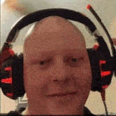 a bald man wearing headphones with red lights