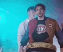 a man in a jacket is holding a tire in his hands .