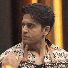 a man wearing a sweater with a pattern on it looks to his left
