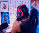 a woman wearing red headphones sits in a chair
