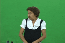 a woman is standing in front of a green screen