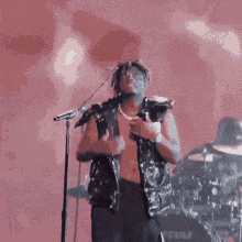a shirtless man is playing a guitar and singing into a microphone .