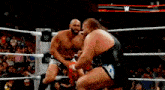 two men are wrestling in a ring and one of them is holding a red towel .