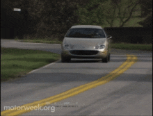 a car is driving down a road with motorweek.org written on the bottom of the screen