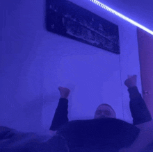 a man in a black shirt is sitting in a dark room