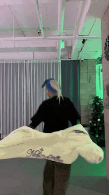 a person wearing a blue headband is holding a white shirt that says ' ncr ' on it