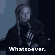 a woman holding a microphone with the words " whatsoever " above her