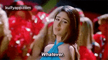 a woman in a blue dress is saying `` whatever '' in front of a crowd of people .