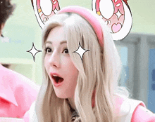 a close up of a woman wearing a pink headband with bunny ears .