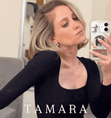a woman taking a selfie in front of a mirror with the name tamara