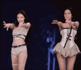 two women are standing next to each other on a stage .