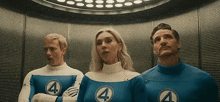 a man and a woman are standing next to each other in an elevator wearing fantastic four costumes .