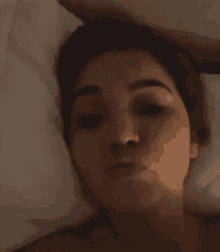 a woman laying in bed with a nose ring on her nose