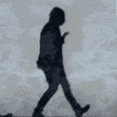 a silhouette of a person in a trench coat is dancing