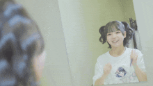 a girl is looking at herself in a mirror