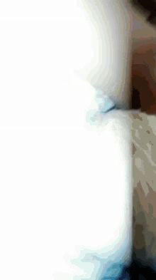 a close up of a person laying on a bed with blue sheets