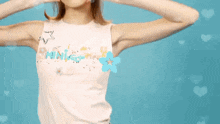 a woman wearing a white tank top with the word mini on the front