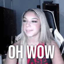 a woman is sitting in a chair with the words oh wow written on her chest .