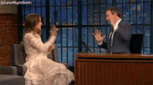 a woman in a white dress is sitting in front of a man in a suit and tie .