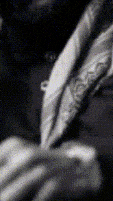 a black and white photo of a person holding a pen .