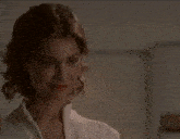 a woman in a white shirt is looking down at something