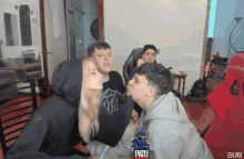 a man in a paris shirt kisses a woman in a hoodie