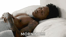 a shirtless man is laying on a bed with the words morning written on the bottom