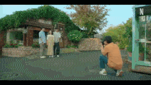 a man is taking a picture of a group of people standing in front of a store called evers