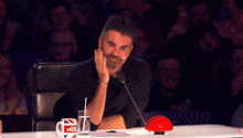 a man sits at a table with a cup that says potter