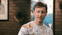 a man wearing a tie dye shirt says kiss my ass