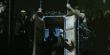 an aerial view of a group of people standing around a cage with a person in it