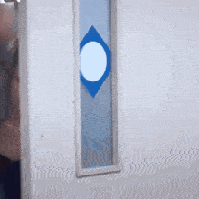 a woman is looking out of a door with a blue diamond on it .