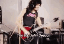 a man playing a guitar with the words two tits john deacon written below him