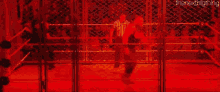 a blurry picture of a person standing in a ring with a red background .