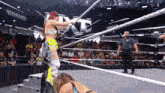two women are wrestling in a wrestling ring while a referee looks on .