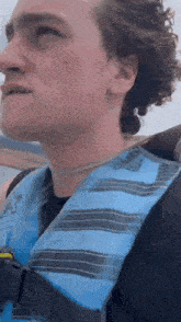 a young man wearing a life vest is riding a boat .