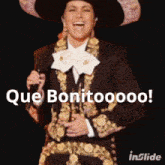 a woman in a mariachi outfit is holding a microphone and says que bonitoooo on the bottom