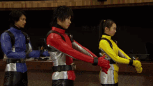 a man in a red jacket is standing next to two other people