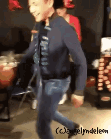 a man in a blue jacket and jeans is dancing with the name angelyndeleon on the bottom of the image