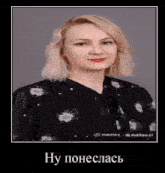 a woman with blonde hair is wearing a black dress with flowers on it and a bow tie .