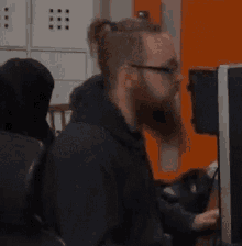 a man with a beard is sitting in front of a computer monitor