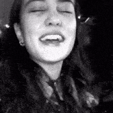 a black and white photo of a woman with her eyes closed and her mouth open
