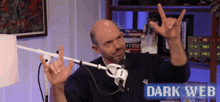 a man in front of a microphone with the words dark web on the bottom right